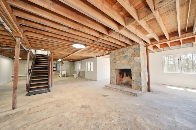 basement with stairs, a fireplace, and plenty of natural light