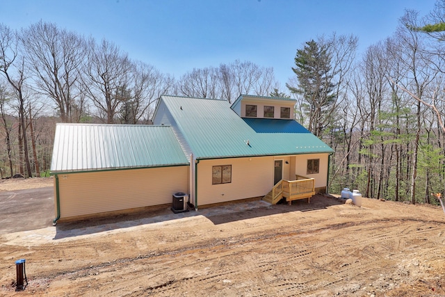 back of property featuring a wooden deck, metal roof, and central air condition unit