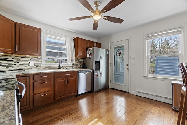 kitchen with stainless steel appliances, tasteful backsplash, plenty of natural light, ceiling fan, and a baseboard radiator
