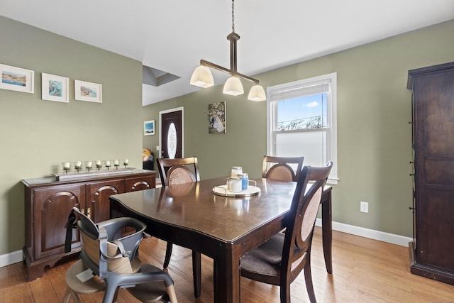 dining area with light wood-style floors and baseboards