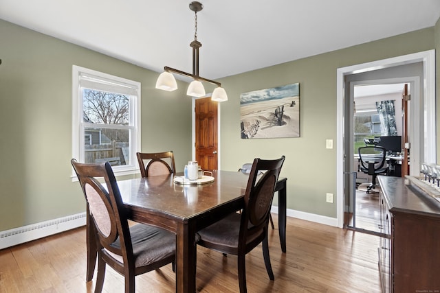 dining space featuring baseboards, wood finished floors, and a healthy amount of sunlight