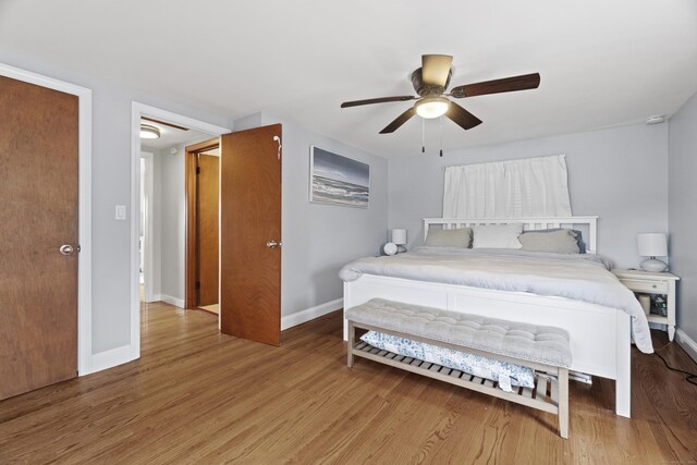 bedroom with baseboards, wood finished floors, and ceiling fan