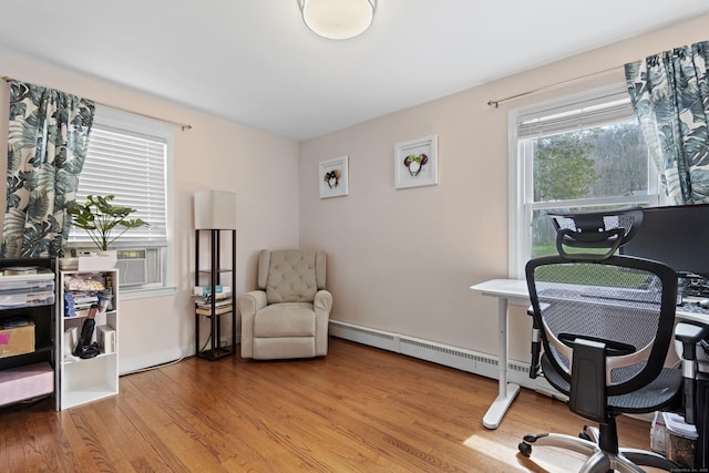 office space featuring baseboard heating, baseboards, light wood-style floors, and cooling unit