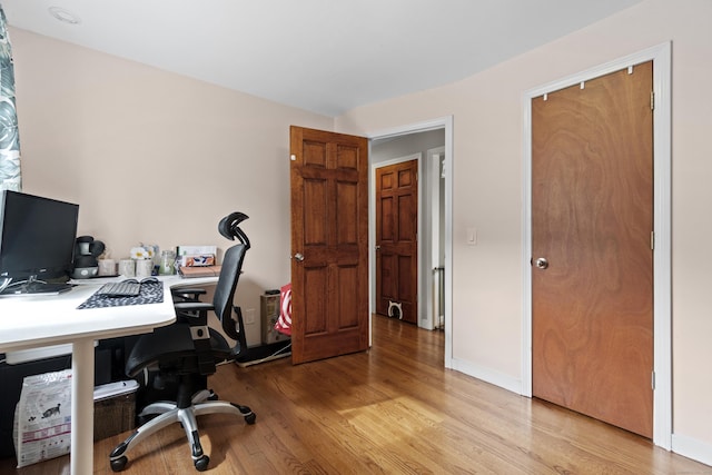 home office featuring baseboards and light wood-style flooring