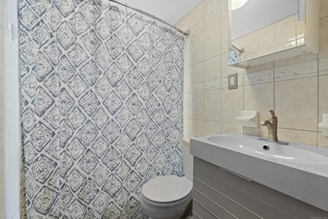 full bath with toilet, vanity, curtained shower, and tile walls