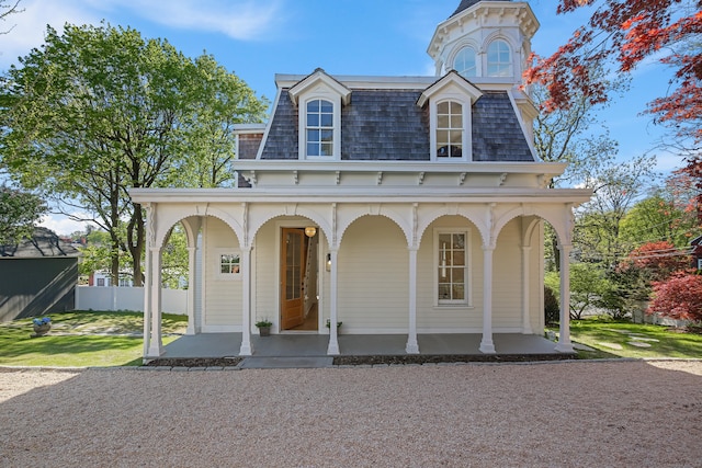 view of front facade featuring roof with shingles, a porch, and mansard roof