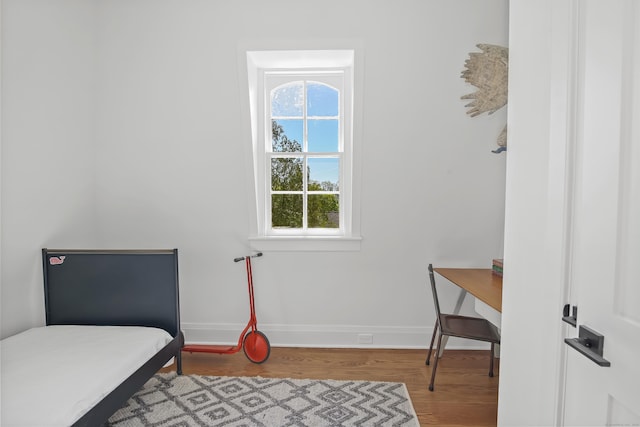 bedroom featuring baseboards and wood finished floors