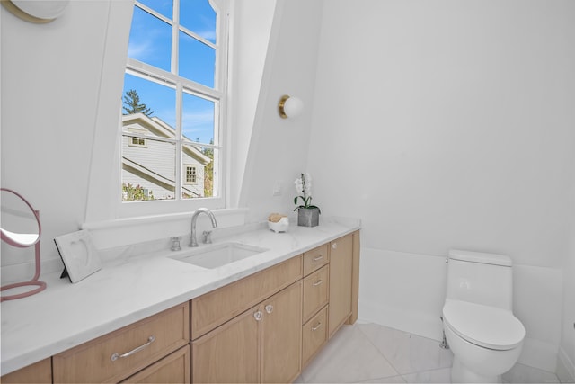 bathroom featuring vanity, baseboards, and toilet