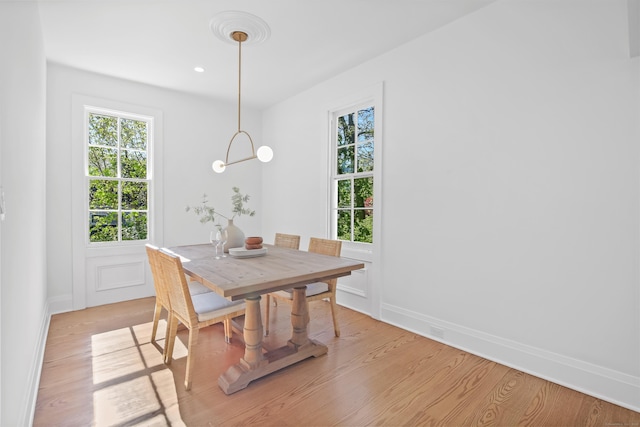 dining area featuring baseboards and light wood-style flooring