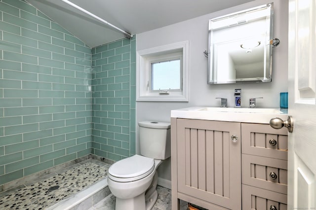 full bath with a stall shower, toilet, vaulted ceiling, baseboards, and vanity