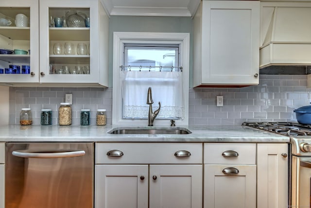 kitchen with white cabinets, a sink, glass insert cabinets, appliances with stainless steel finishes, and premium range hood