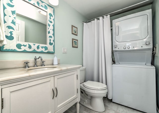 bathroom featuring vanity, stacked washing maching and dryer, a shower with curtain, toilet, and tile patterned flooring
