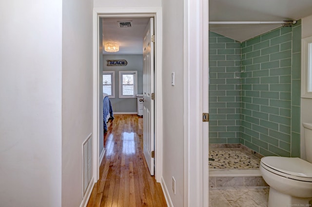 full bathroom featuring hardwood / wood-style floors, visible vents, a shower stall, and toilet