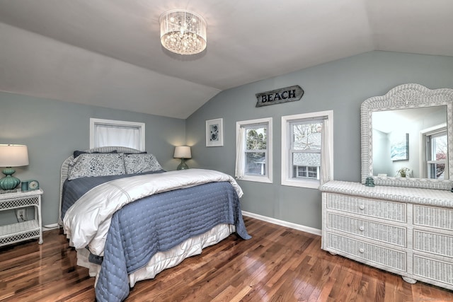 bedroom with lofted ceiling, a chandelier, wood finished floors, and baseboards
