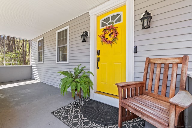 view of exterior entry featuring covered porch