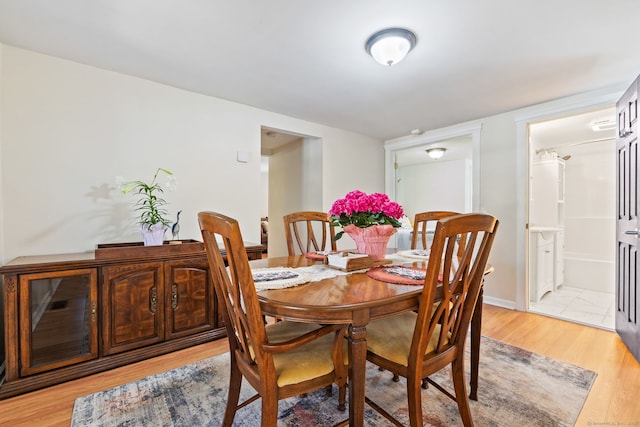 dining area with baseboards and light wood finished floors