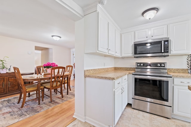 kitchen with light countertops, white cabinets, and appliances with stainless steel finishes