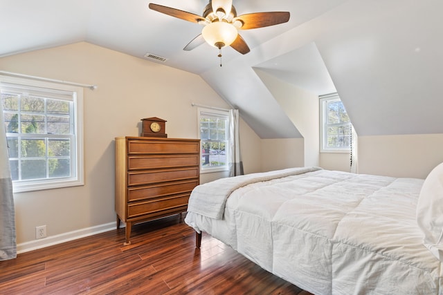 bedroom with ceiling fan, visible vents, vaulted ceiling, wood finished floors, and baseboards