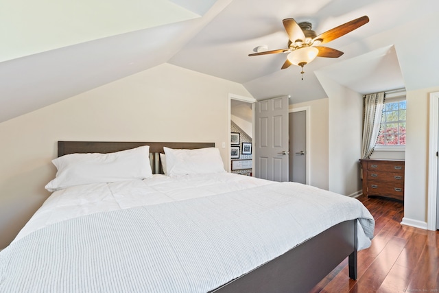 bedroom with baseboards, ceiling fan, vaulted ceiling, and wood finished floors
