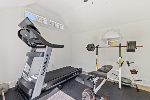 exercise room with baseboards and vaulted ceiling