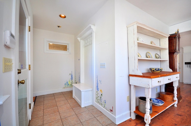 hallway with light tile patterned floors, recessed lighting, and baseboards