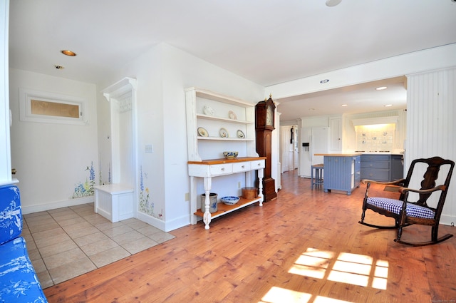 living area with recessed lighting, light wood-style flooring, and baseboards