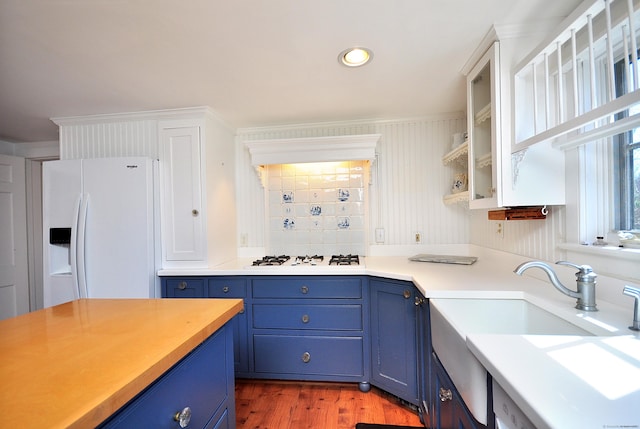 kitchen featuring a sink, light countertops, blue cabinets, wood finished floors, and white appliances