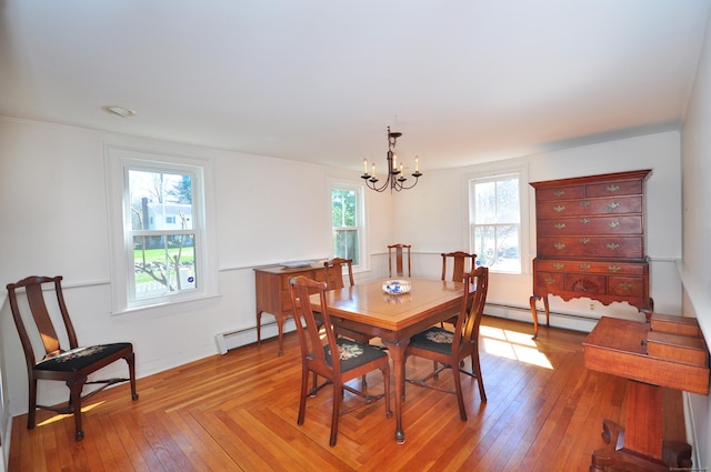 dining space with baseboard heating, an inviting chandelier, and light wood finished floors