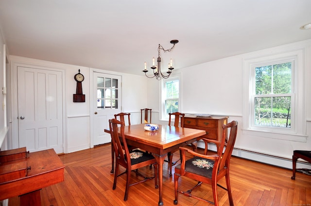 dining area featuring a chandelier, baseboard heating, and a healthy amount of sunlight