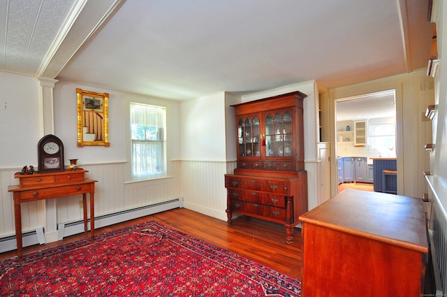 living area with crown molding, wainscoting, and wood finished floors