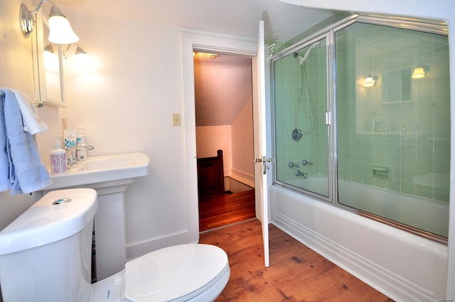 full bathroom with combined bath / shower with glass door, wood finished floors, and toilet