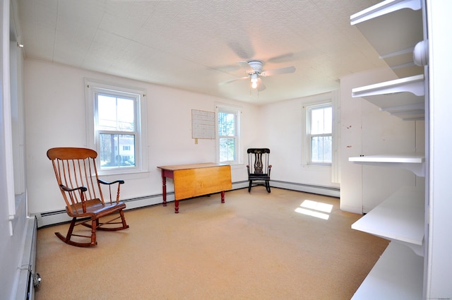 living area with a ceiling fan and carpet