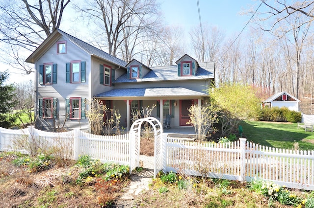 view of front of house featuring a porch, a front lawn, a fenced front yard, and roof with shingles