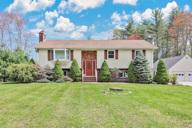 split foyer home featuring a garage, an outbuilding, a chimney, and a front yard