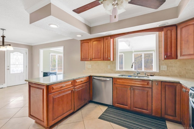 kitchen featuring brown cabinetry, a ceiling fan, a peninsula, a sink, and stainless steel appliances