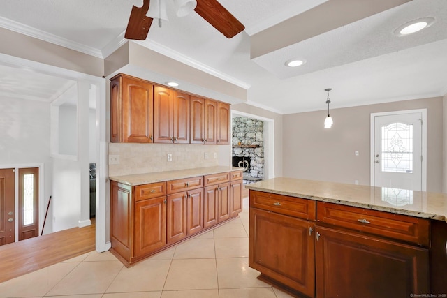 kitchen featuring crown molding, hanging light fixtures, tasteful backsplash, and light tile patterned flooring