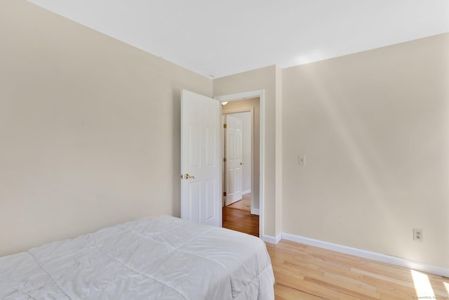 bedroom with baseboards and light wood finished floors
