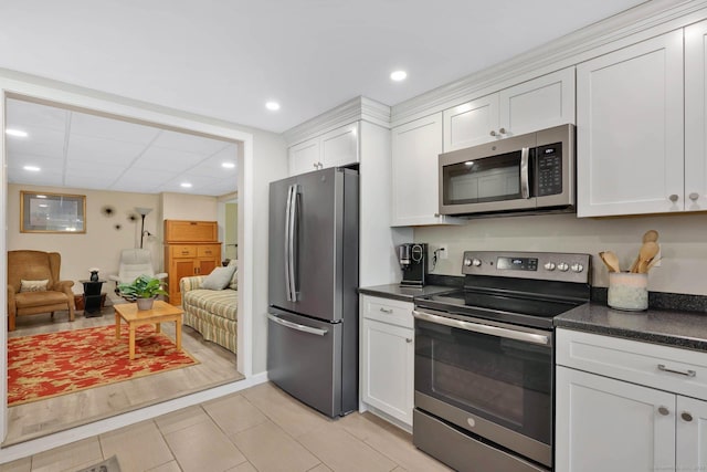 kitchen featuring open floor plan, white cabinetry, appliances with stainless steel finishes, and dark countertops