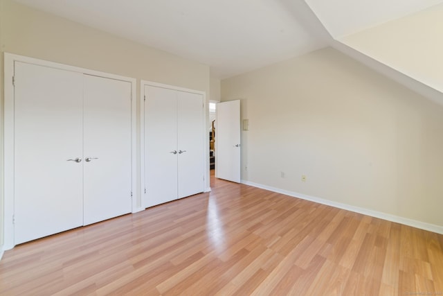72 Montoya Dr Unit 72, Branford, CT 06405 - unfurnished bedroom featuring light wood finished floors, multiple closets, baseboards, and lofted ceiling
