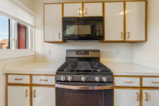 72 Montoya Dr Unit 72, Branford, CT 06405 - kitchen featuring light countertops, black microwave, gas stove, and white cabinetry