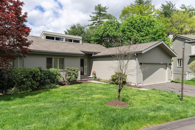 view of front of home featuring an attached garage, roof with shingles, a front yard, and driveway