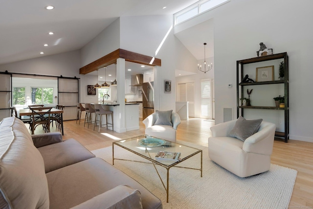 living room with light wood-type flooring, high vaulted ceiling, recessed lighting, a chandelier, and baseboards