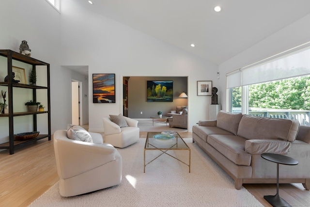 living area with light wood-style floors, high vaulted ceiling, and recessed lighting