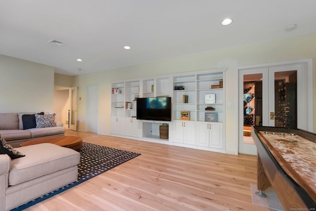 living area featuring light wood finished floors, recessed lighting, and french doors