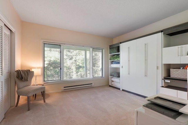 sitting room with a baseboard heating unit and light colored carpet