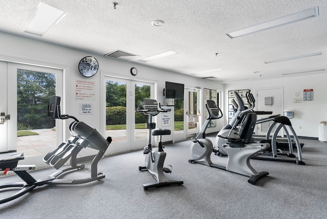 workout area featuring french doors and a textured ceiling