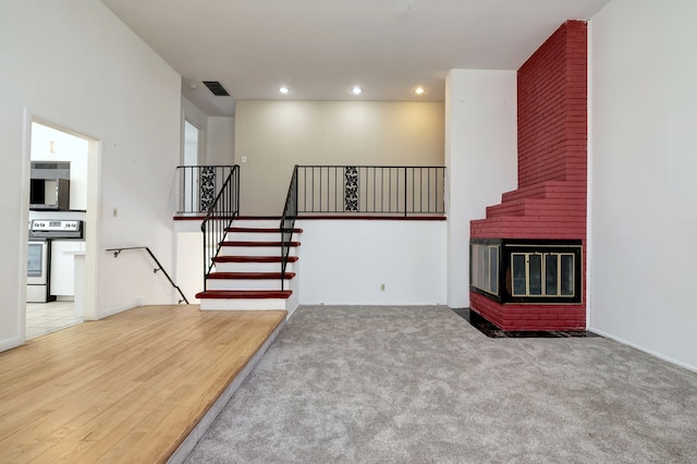 472 Westover Rd, Stamford, CT 06902 - unfurnished living room with recessed lighting, stairway, visible vents, carpet floors, and a brick fireplace