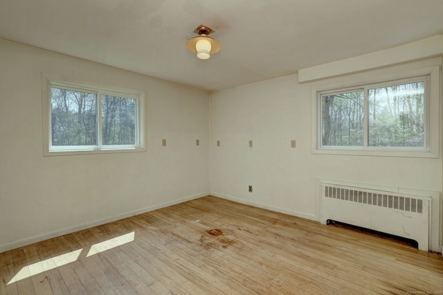472 Westover Rd, Stamford, CT 06902 - unfurnished room with radiator heating unit, baseboards, light wood-style floors, and a healthy amount of sunlight