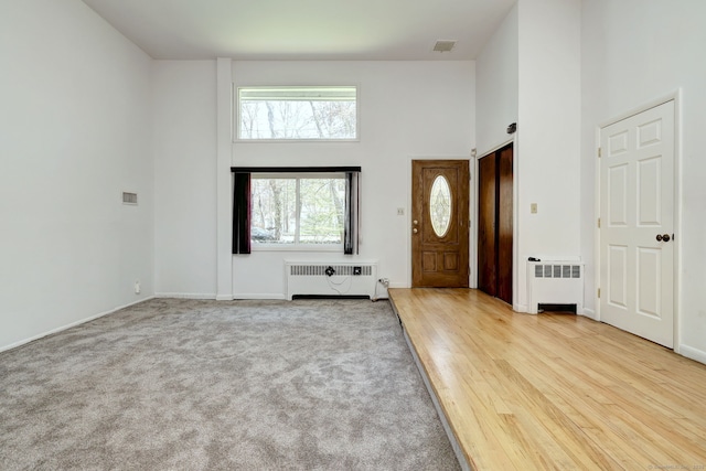 472 Westover Rd, Stamford, CT 06902 - carpeted foyer with radiator heating unit, a towering ceiling, and visible vents