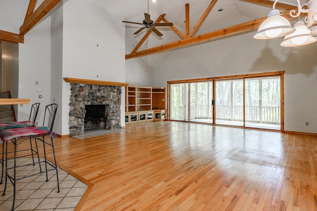 9 Stonehedge Way, Granby, CT 06060 - living area with a ceiling fan, a stone fireplace, high vaulted ceiling, baseboards, and light wood-style flooring